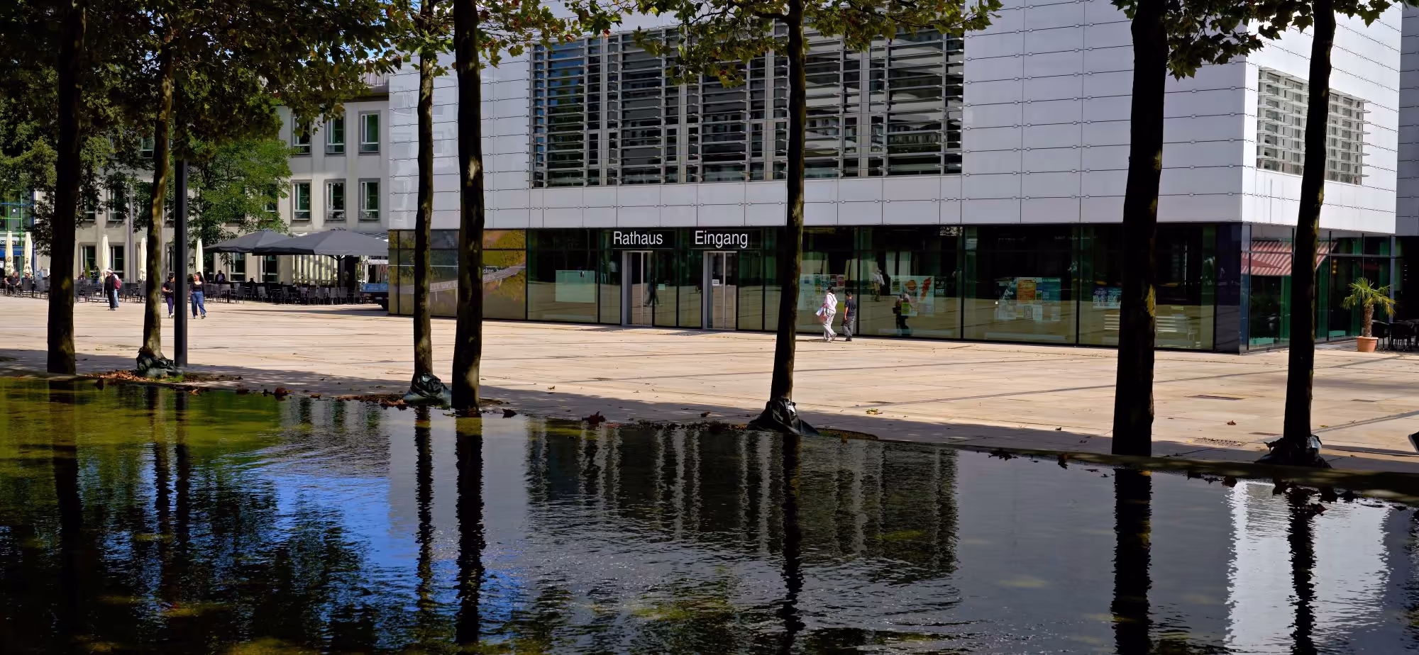 Eingang des Rathauses Lüdenscheid am Rathausplatz mit Wasserbecken und Platanen
